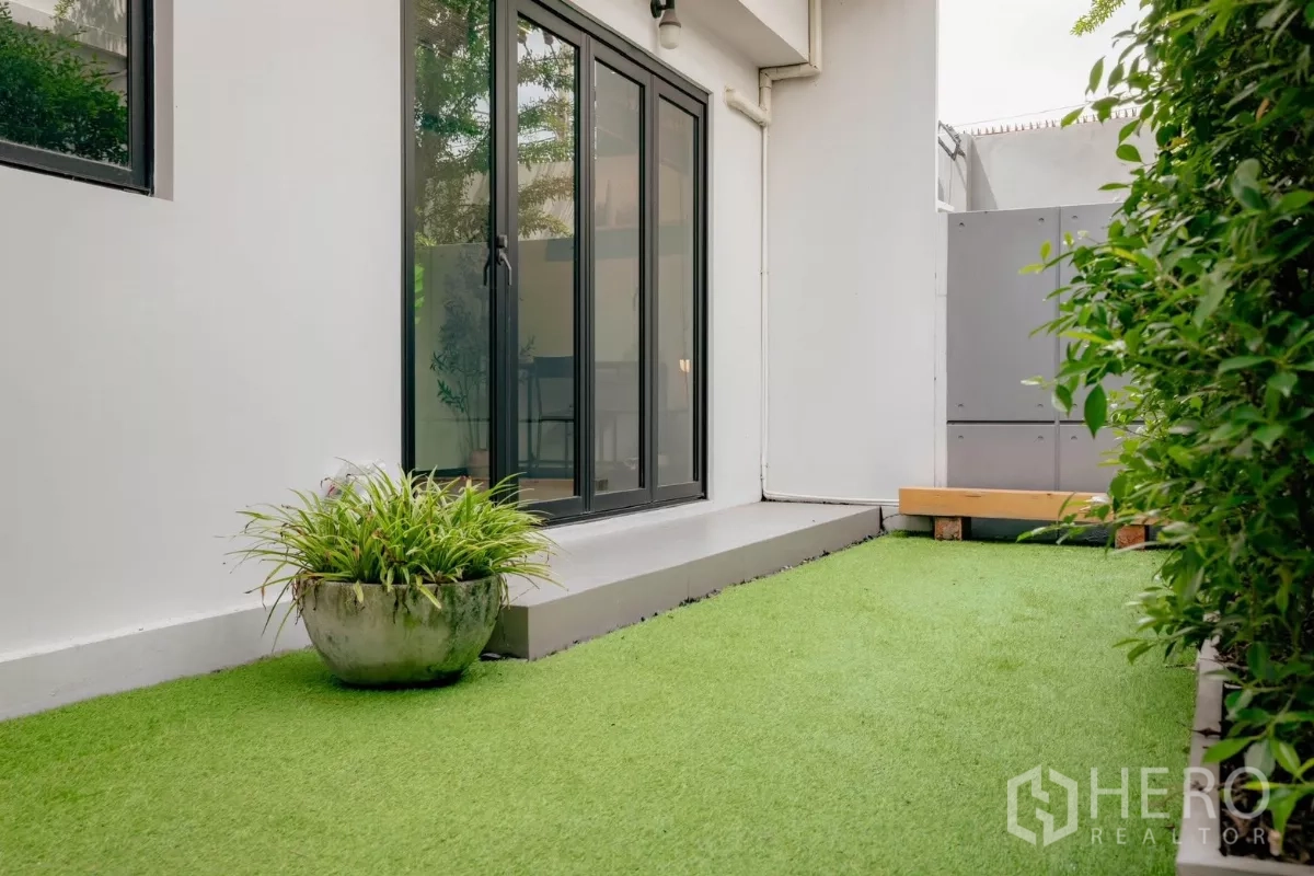 Detached House for rent or sale in Bang Phli, Samut Prakan - Private backyard with artificial lawn and sliding doors to the house.