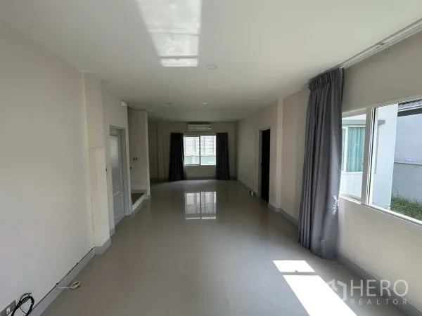 Detached House for rent in Khlong Luang, Pathum Thani - Long living room with windows on both sides bringing in natural light.