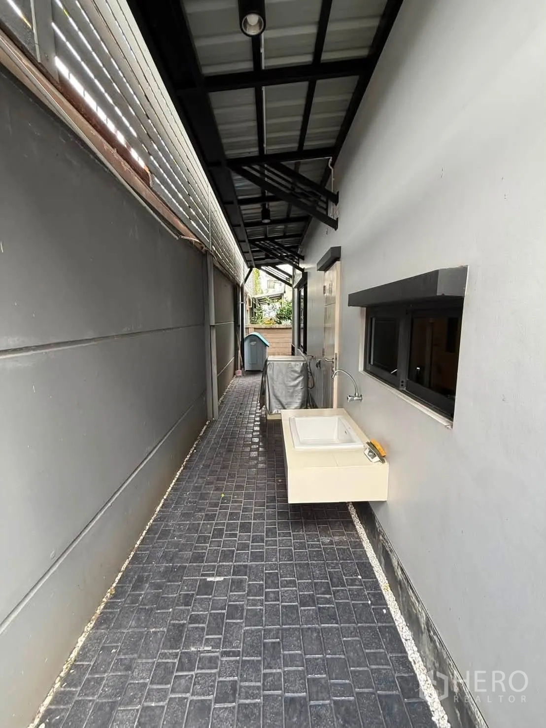 Detached House for rent in Bang Kapi, Bangkok - Service walkway under a canopy with an outdoor sink and tiled floor.
