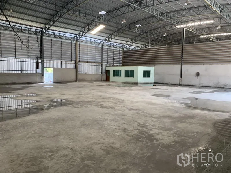 Warehouse for rent in Bueng Kum, Bangkok - Spacious warehouse interior featuring a high steel-truss roof, concrete floor and a built-in office room.