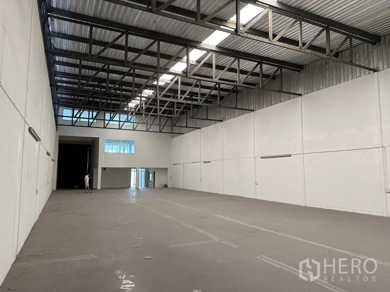 Factory for rent in Bang Sao Thong, Samut Prakan - High-clearance warehouse hall with steel roof trusses, skylight strip and smooth floor.