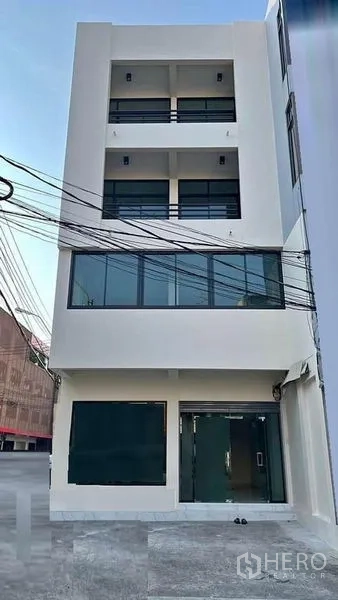 店屋 出租在Bang Kapi, Bangkok - 现代四层商铺正立面，配阳台与大玻璃窗。