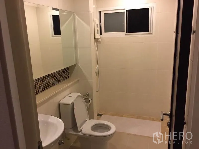 Detached House for rent or sale in Khlong Toei, Bangkok - Second bathroom with large mirror, toilet and separate shower area with small window.