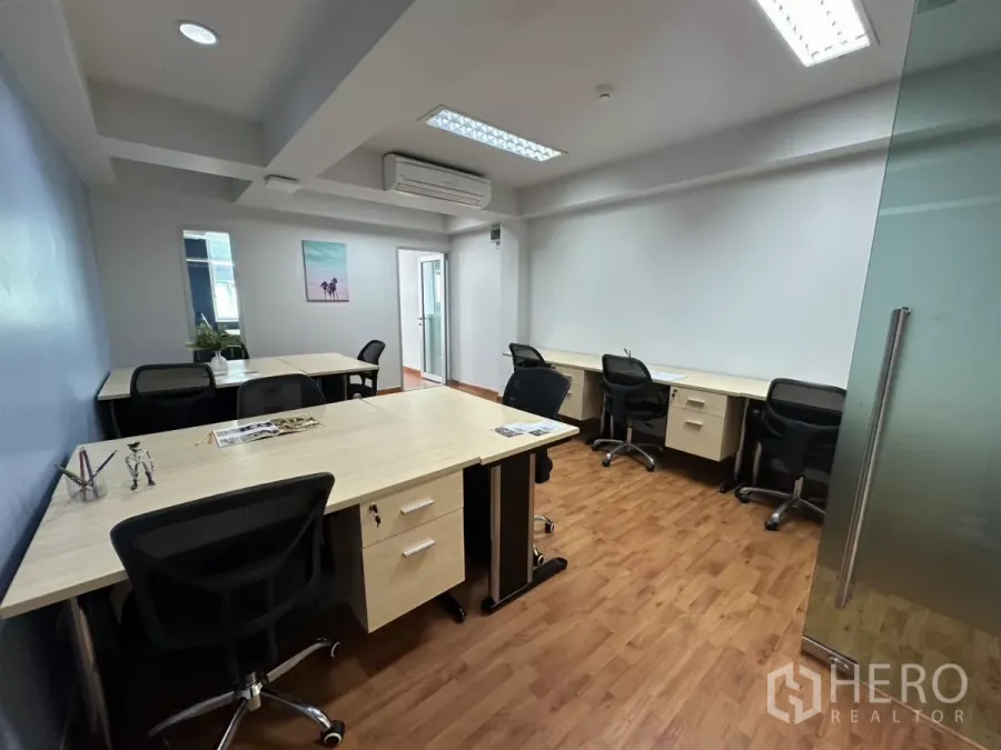 สำนักงาน ให้เช่าในWatthana, Bangkok - ออฟฟิศแบบเปิดพร้อมโต๊ะทำงานหลายชุด เก้าอี้ตาข่าย พื้นลามิเนต และประตูกระจก