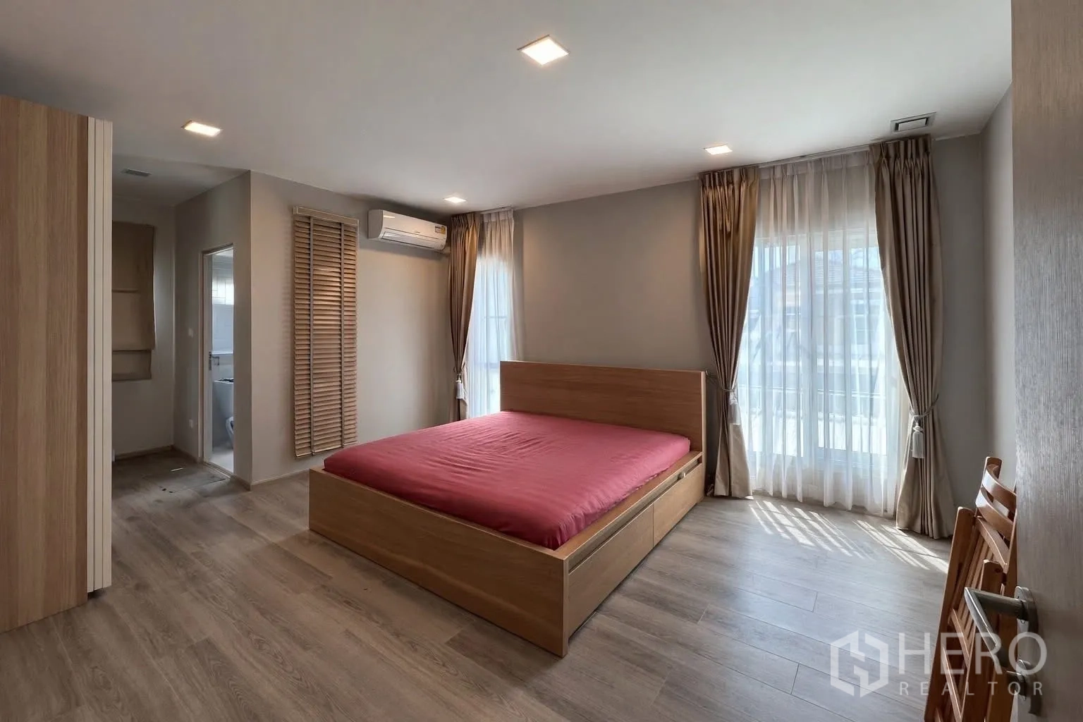 半独立式住宅 for rent in Prawet, Bangkok - 主卧配大窗、木床与套间入口。