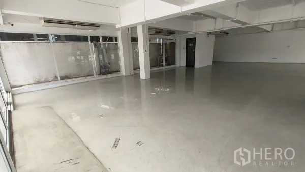 办公空间 出租在Khlong Toei, Bangkok - 展示厅式开放空间，落地窗和柱子。