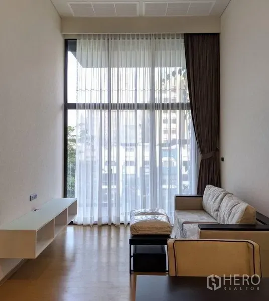 คอนโด ให้เช่าในWatthana, Bangkok - ห้องนั่งเล่นเพดานสูงสองชั้น หน้าต่างกระจกเต็มบานพร้อมโซฟา