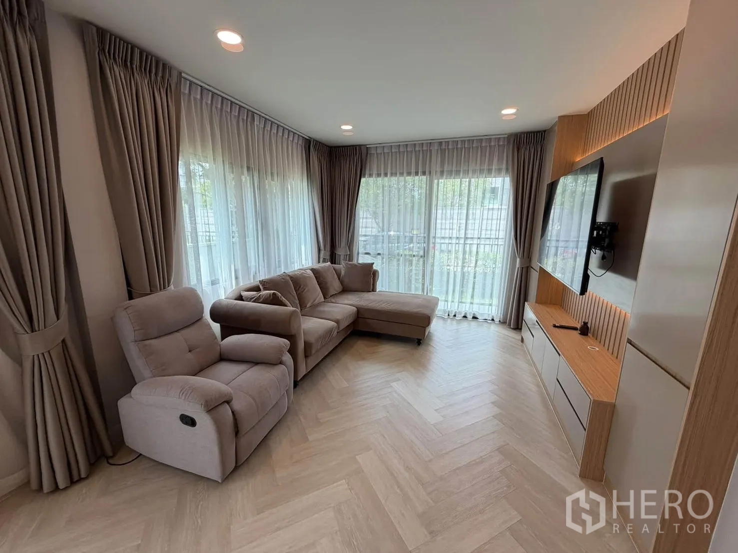 独栋房屋 for rent in Bang Phli, Samut Prakan - 客厅配转角沙发、躺椅与电视背景墙。
