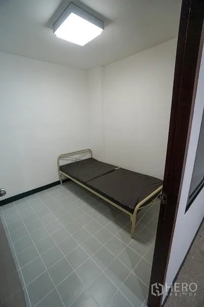 房间 出租在Watthana, Bangkok - 小型女佣房，单人床与地砖地面。