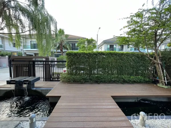 บ้าน ให้เช่าในSuan Luang, Bangkok - ลานหน้าแบบพื้นไม้พร้อมน้ำตกตกแต่ง มองออกไปยังถนนหลังแนวรั้วไม้พุ่ม