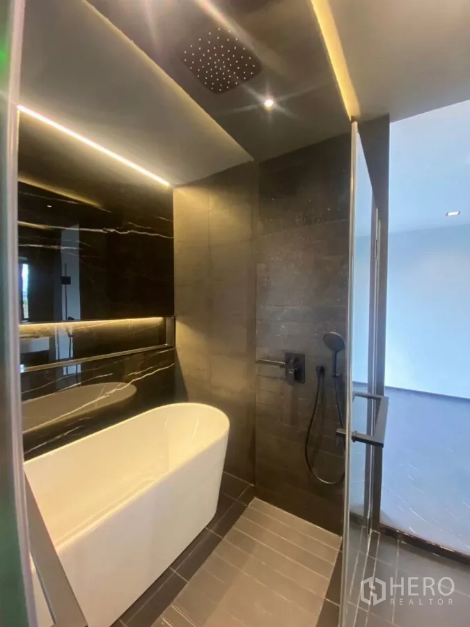 Townhouse for rent in Huai Khwang, Bangkok - Bathroom with freestanding tub, rain shower and a backlit mirror.