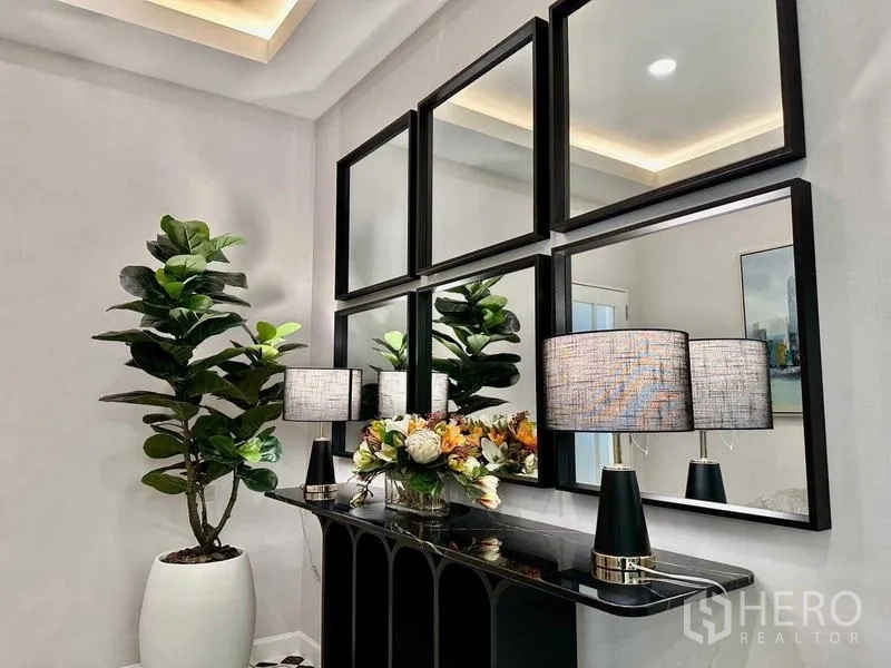 独立式住宅 出租在Bang Phli, Samut Prakan - 玄关台上摆放镜框、台灯与室内绿植。