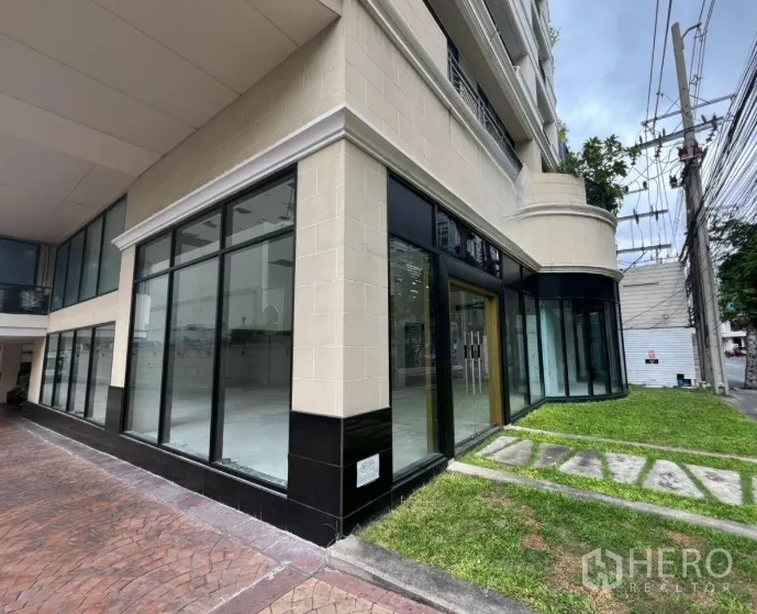 零售空间 出租在Watthana, Bangkok - 建筑外角，环绕玻璃立面与草坪带