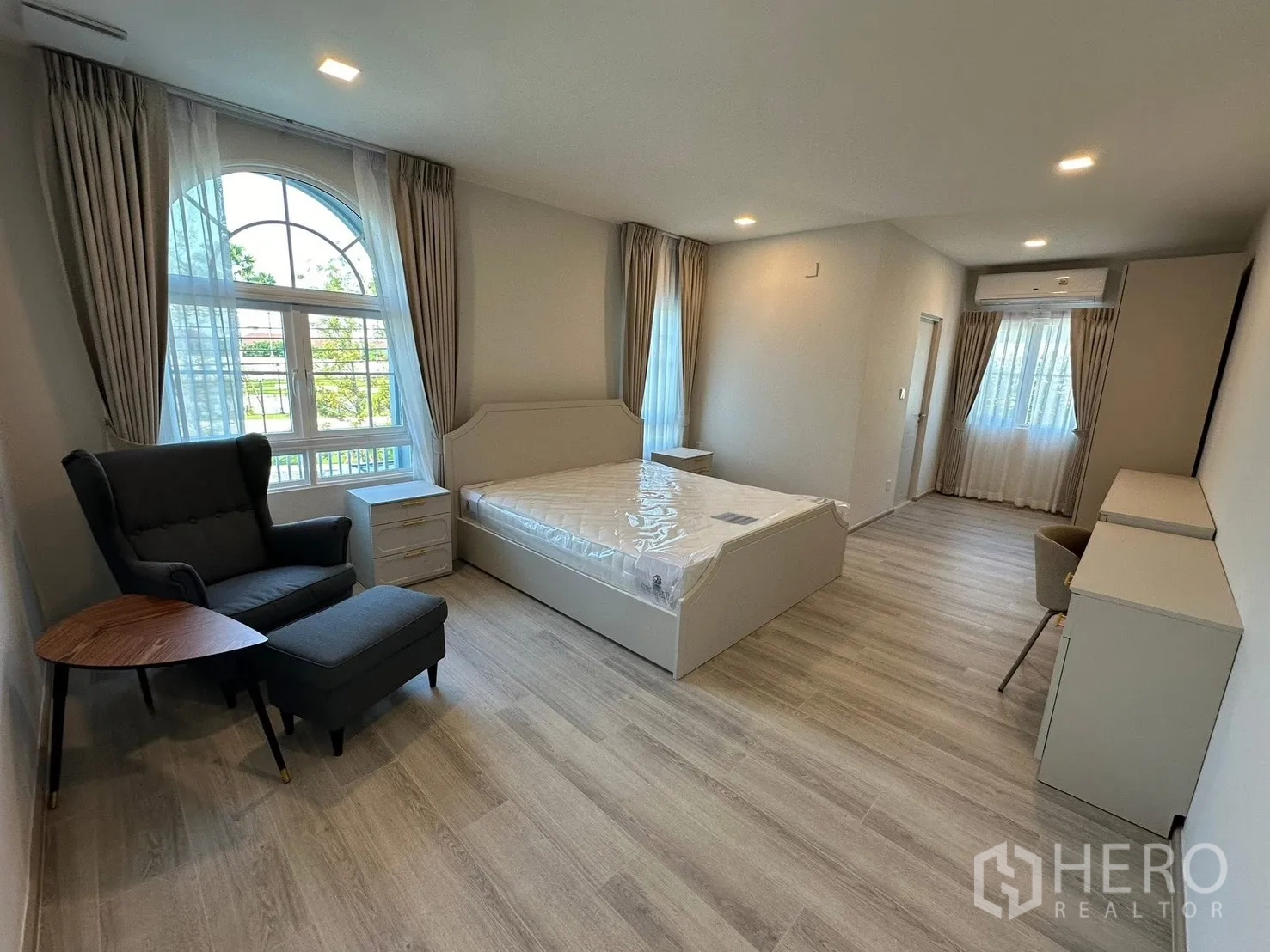 独栋房屋 for rent in Bang Phli, Samut Prakan - 主卧带拱形窗，设休闲单椅与书桌。