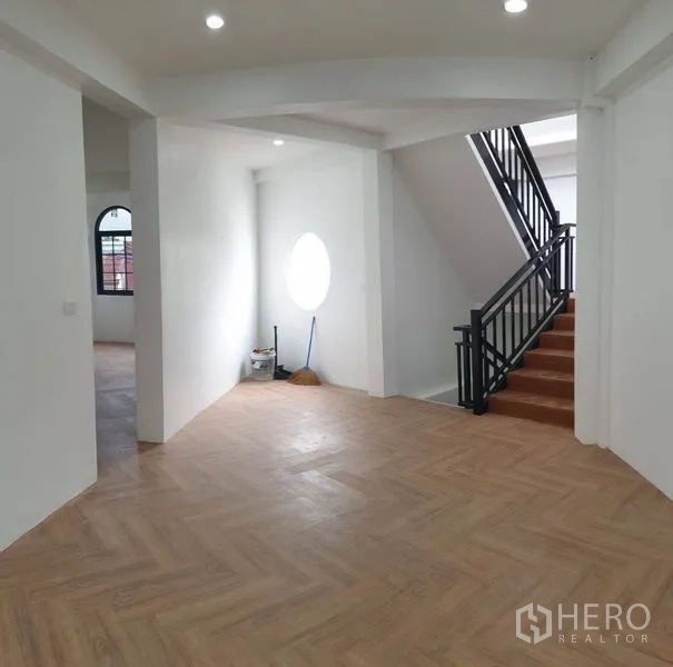 Home Office for rent or sale in Bang Na, Bangkok - Landing with circular window and metal staircase to the upper floor.