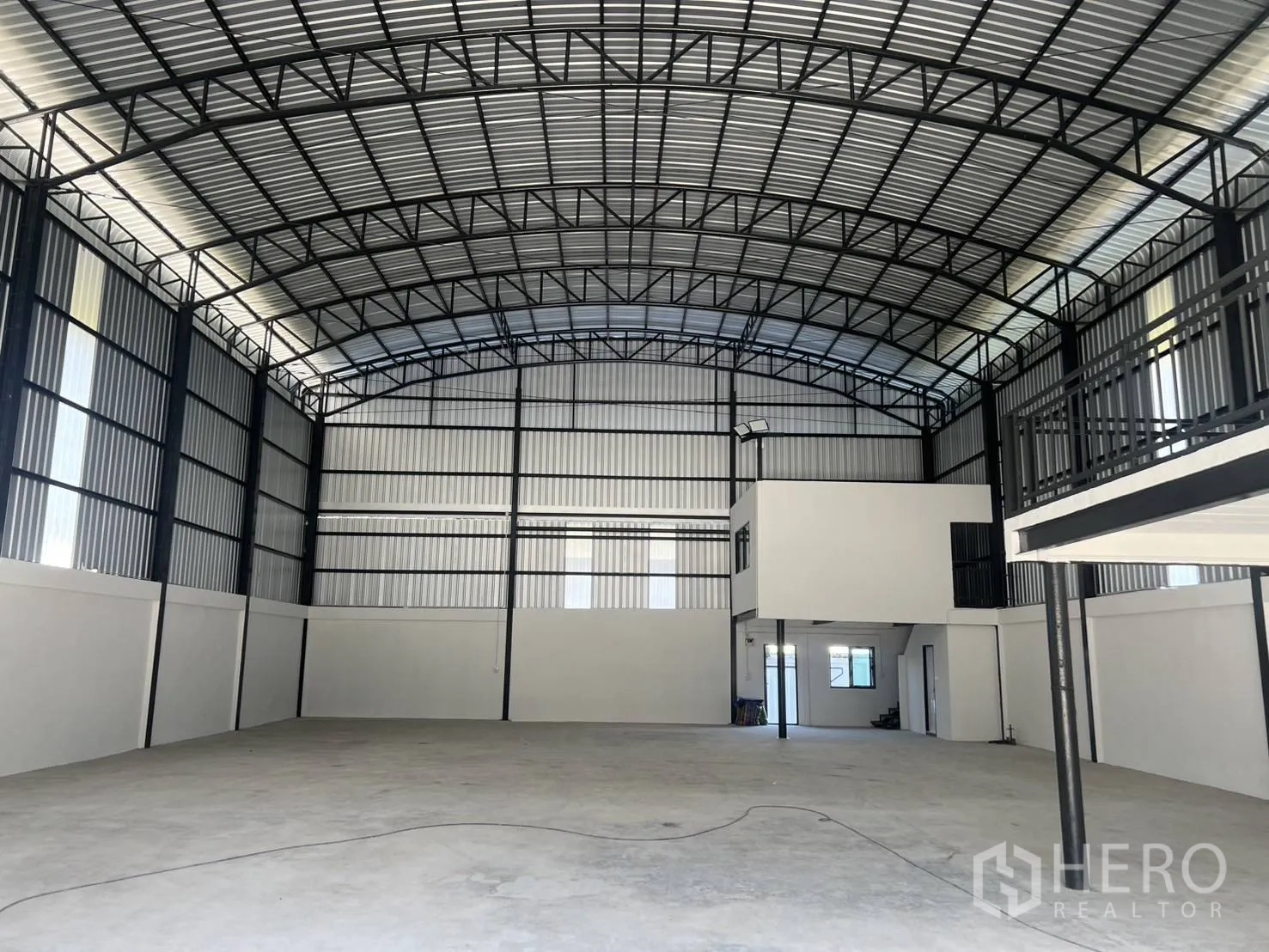 仓库 for rent in Bang Phli, Samut Prakan - 钢结构仓库内部，拱形高屋顶，混凝土空地与夹层办公室。