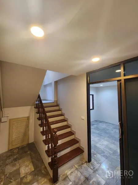 联排别墅 出租在Wang Thonglang, Bangkok - 木质楼梯，旁有玻璃隔断房间与走廊。
