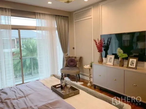 Detached House for rent or sale in Bang Phli, Samut Prakan - Primary bedroom with balcony doors, TV console and soft neutral decor.