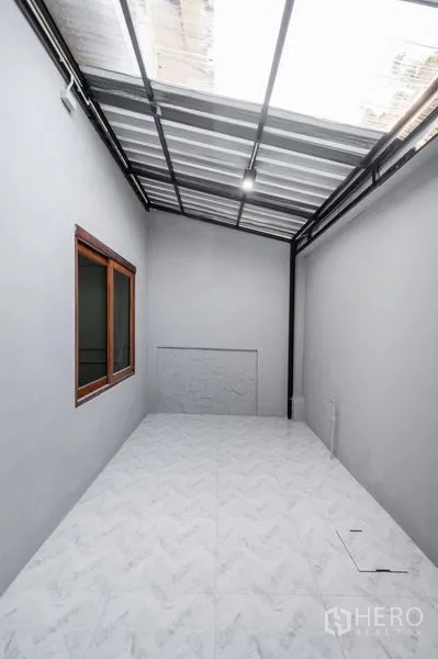 Townhouse for sale - Covered utility terrace with skylight roof and tiled flooring.