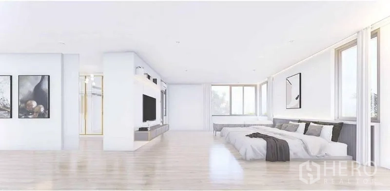 Detached House for rent in Lat Phrao, Bangkok - Large bright bedroom with platform bed, TV wall, wide windows and pale wood floors.
