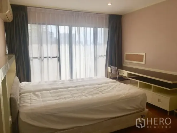 公寓 出租在Watthana, Bangkok - 主卧配大床、薄纱窗帘、书桌并可通往阳台。