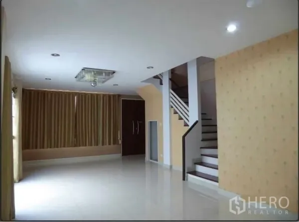 Home Office for rent in Bueng Kum, Bangkok - Spacious ground-floor living area with glossy tile floors, recessed lights and a staircase.