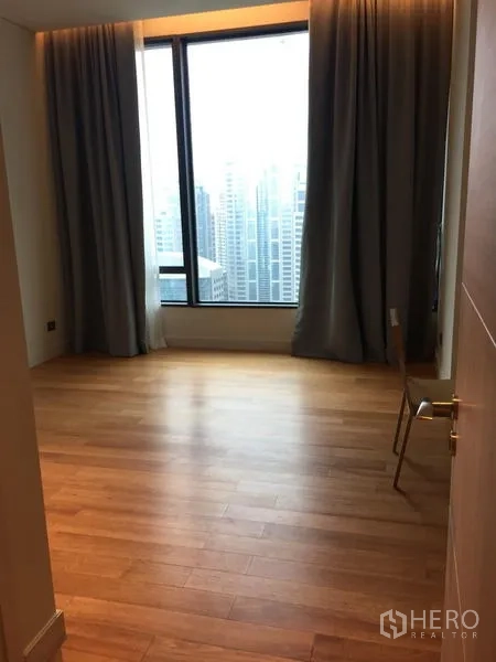 Condominium for rent in Pathum Wan, Bangkok - Spacious bedroom with large window, wood floors and expansive skyline outlook.