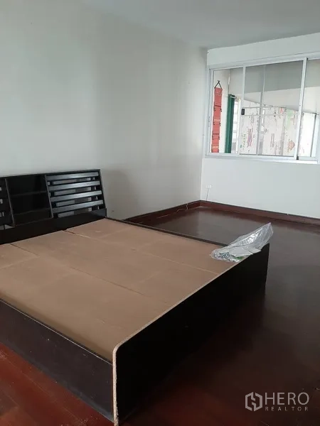 Retail Space for rent in Watthana, Bangkok - Spacious room with wooden floors and platform bed frames beside a large window.