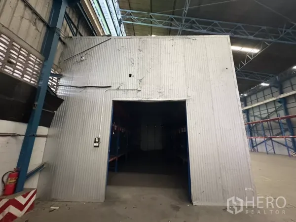 Warehouse for rent in Mueang Samut Prakan, Samut Prakan - Enclosed metal storage room inside the warehouse with an open doorway.