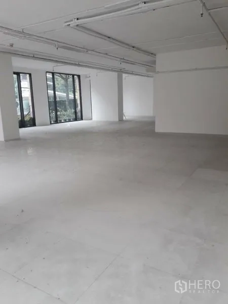 Retail Space for rent in Watthana, Bangkok - Open-plan retail interior with white walls, tiled floor, and large windows facing the street.