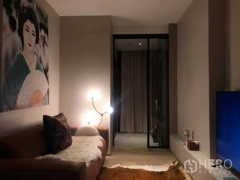 คอนโด ให้เช่าในWatthana, Bangkok - ห้องนั่งเล่นอบอุ่น โซฟาหนัง โคมไฟตั้งพื้น งานศิลปะขนาดใหญ่ และประตูกระจกบานเลื่อนไปยังห้องนอน