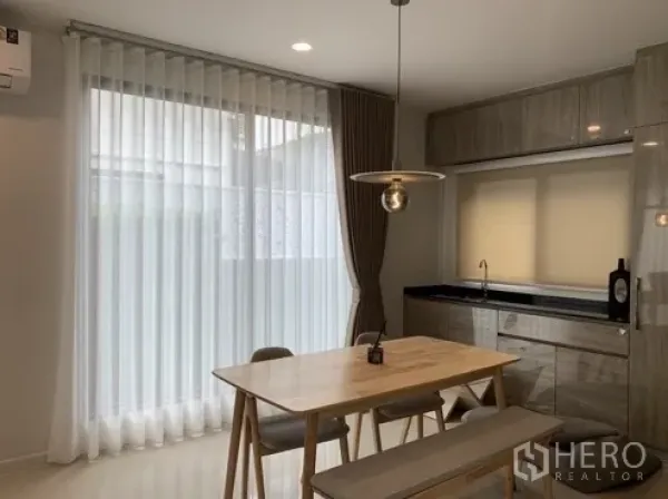 Detached House for rent in Bang Kapi, Bangkok - Bright dining nook with pendant light, built-in pantry and sheer curtains.