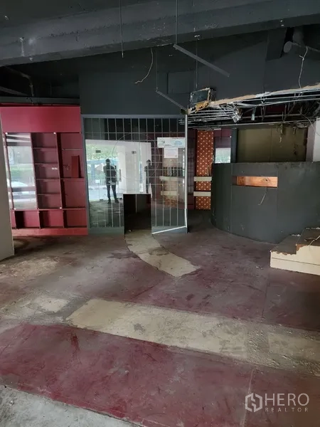 零售空间 出租在Khlong Toei, Bangkok - 店铺内有镜面隔断与吧台，部分天花开放可见管线。