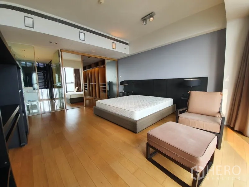 Condominium for rent in Sathon, Bangkok - Master bedroom showing walk-in closet and glass-walled ensuite bathroom.