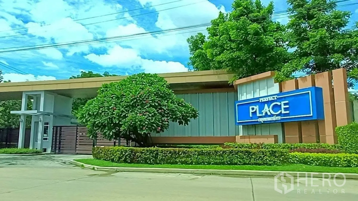 Detached House for rent in Lat Krabang, Bangkok - Gated entrance and security booth of Perfect Place Krungthep-Kreetha community with landscaped greenery.