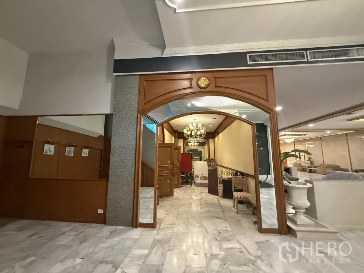 零售空间 出租在Pathum Wan, Bangkok - 零售大堂，铺有大理石地面，木质拱门、镜面与水晶吊灯。