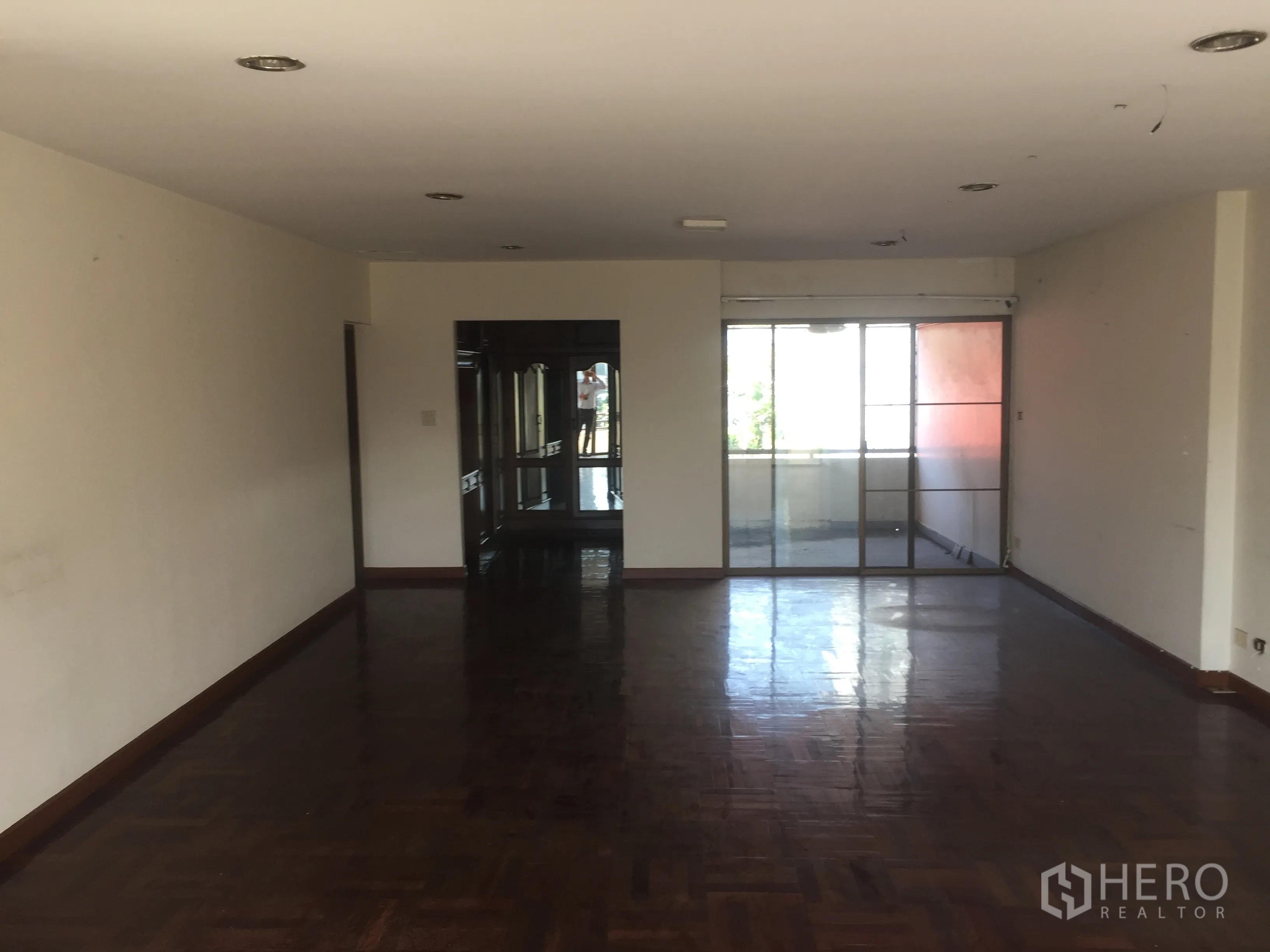 带办公室的家 出售在Watthana, Bangkok - 狭长起居区，拼花木地板，嵌入照明，两端为玻璃门。