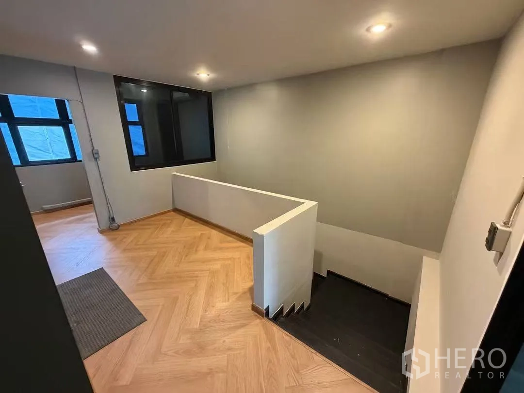 Home Office for rent in Watthana, Bangkok - Upper landing with herringbone wood floor and recessed lighting.