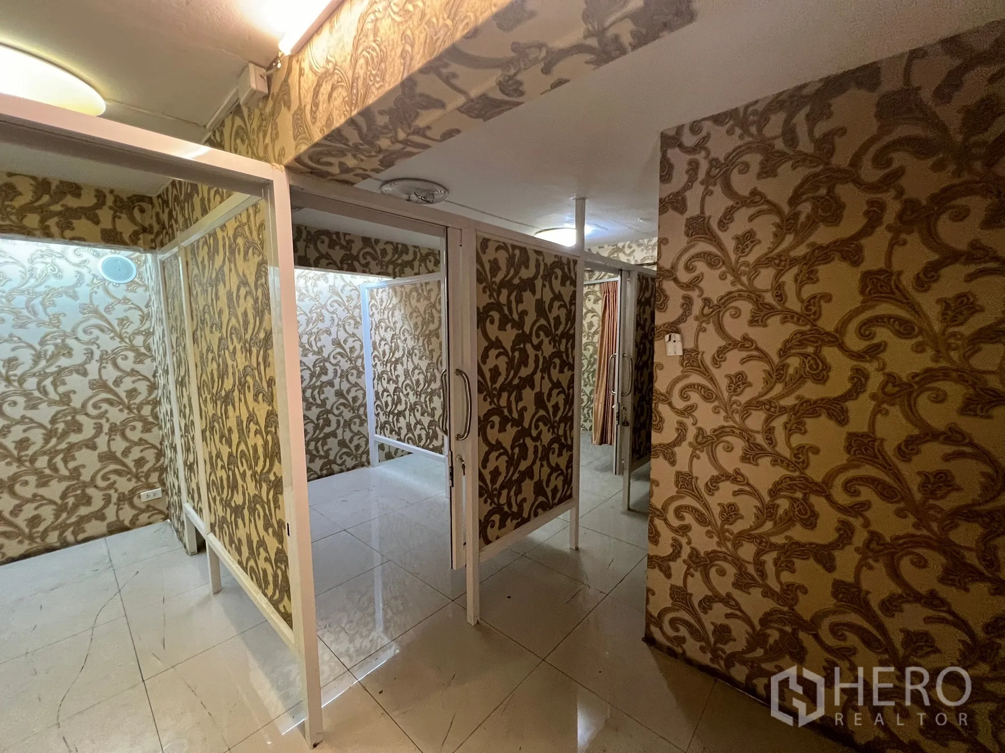 Shophouse for rent in Khlong Toei, Bangkok - Series of partitioned cubicles with sliding glass doors and patterned walls.
