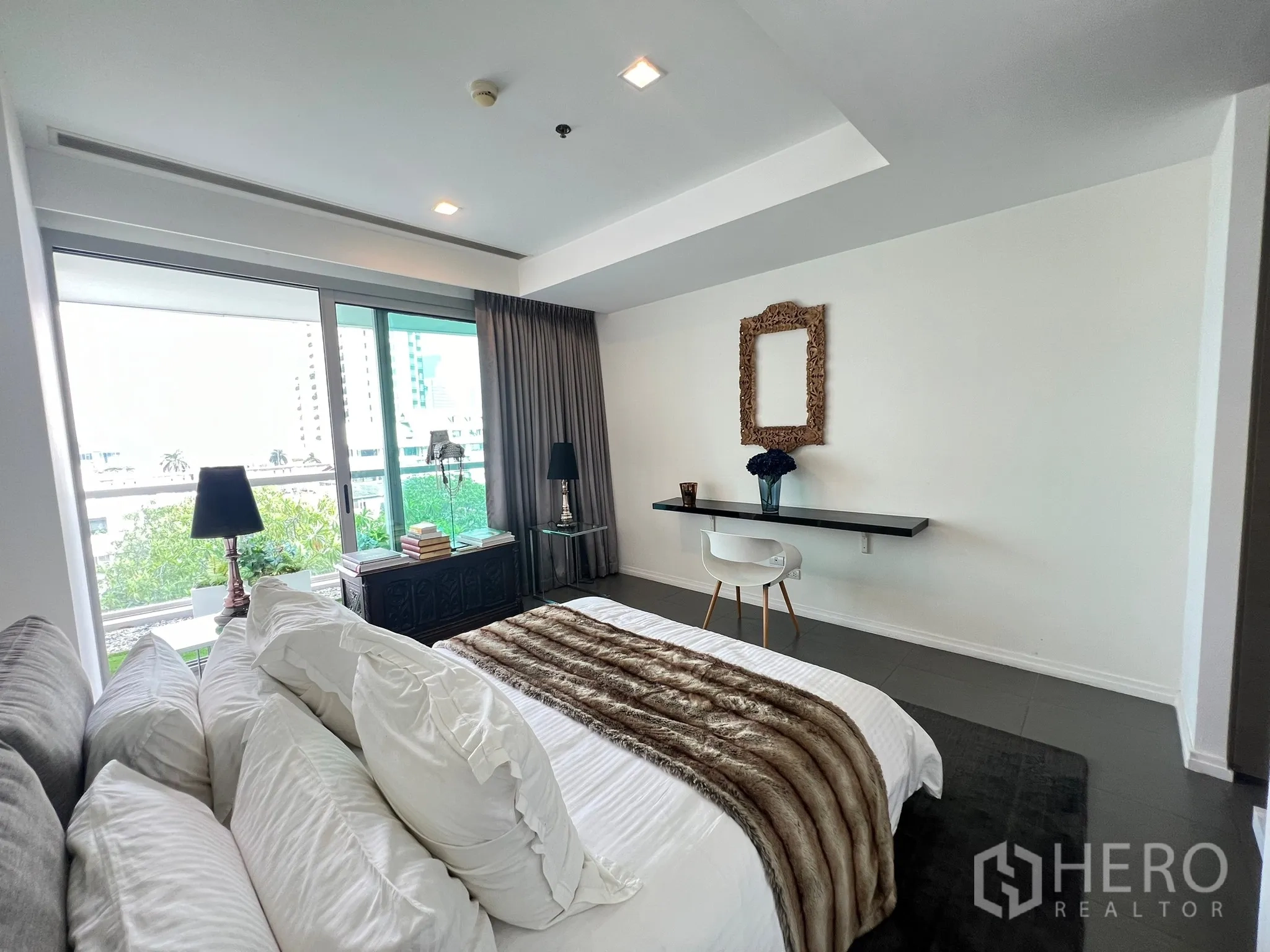 Condominium for sale in Khlong San, Bangkok - Spacious master bedroom with desk, sliding doors, and balcony access.