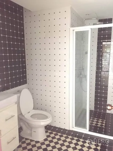 Detached House for rent - Bathroom with glass shower enclosure and black-and-white checkered tiles.