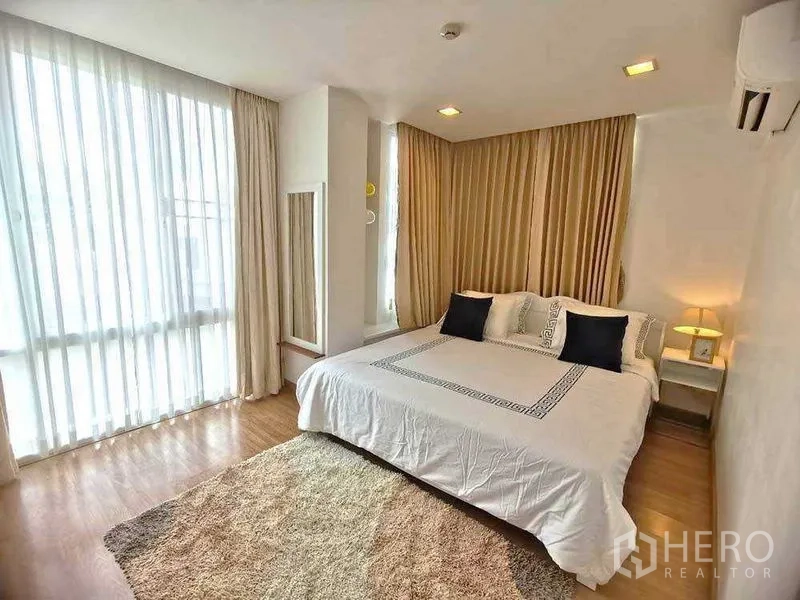 公寓 出租在Watthana, Bangkok - 主卧采光充足，大窗、特大床、米色窗帘与木地板。