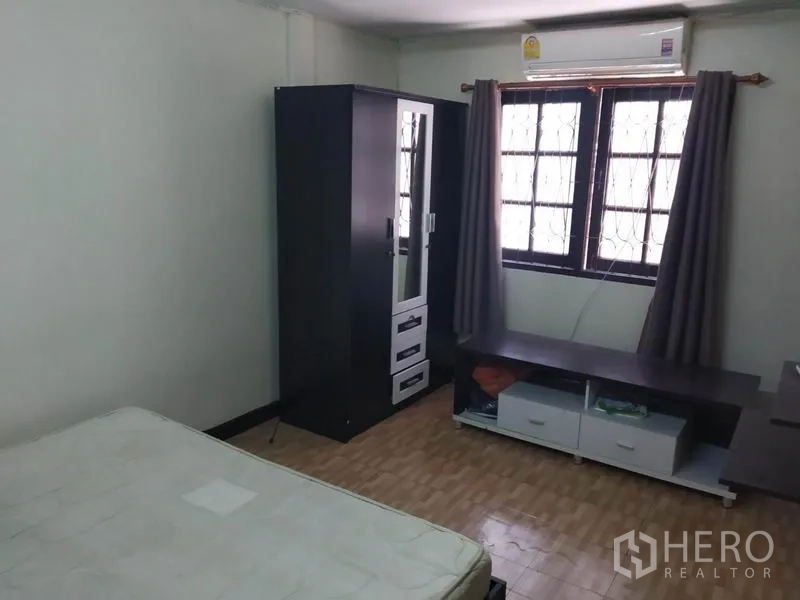 联排别墅 出租或出售在Wang Thonglang, Bangkok - 卧室内配衣柜、电视柜、窗帘和壁挂式空调。