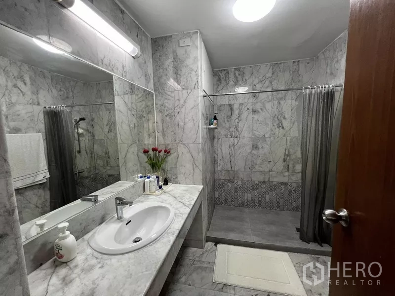 Townhouse for rent or sale in Suan Luang, Bangkok - Bathroom with marble tiles, wide mirror and walk‑in shower.