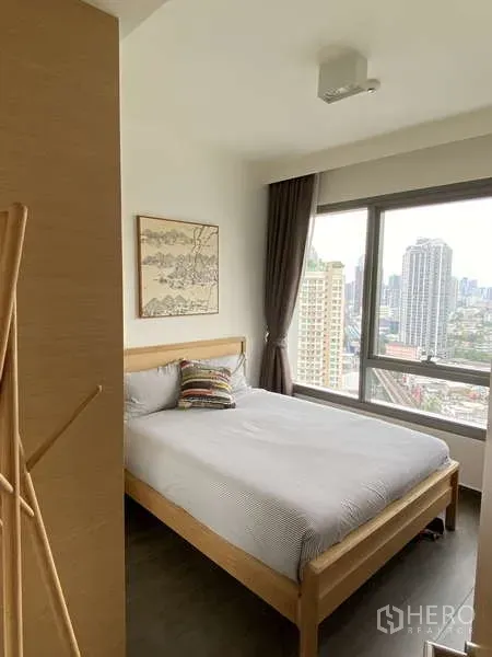 公寓 出售在Watthana, Bangkok - 采光充足的卧室，落地大窗观赏天际线，原木床与素雅装饰。