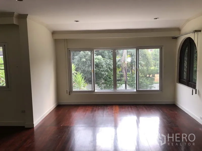 Detached House for rent in Khan Na Yao, Bangkok - Upstairs sitting area with wide picture window overlooking tropical greenery in the garden.