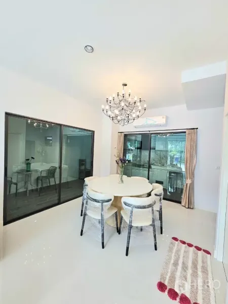 Townhouse for rent in Saphan Sung, Bangkok - Dining room with round table, chandelier and sliding glass doors.