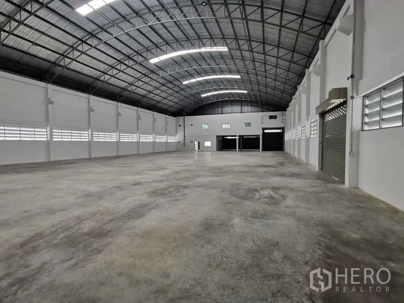 Factory for rent or sale in Bang Bo, Samut Prakan - Open warehouse interior with high arched steel roof and ventilation windows.