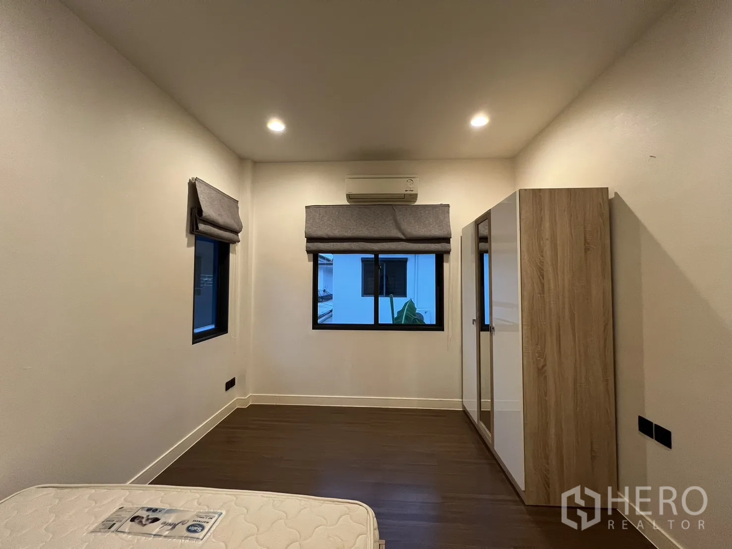 Detached House for rent or sale in Bang Kapi, Bangkok - Bright bedroom with wardrobe and three windows.