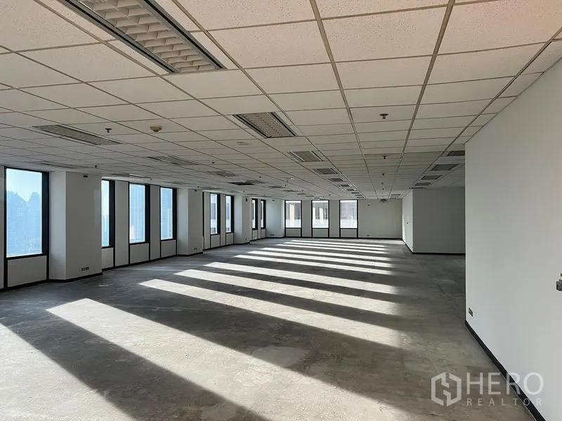 办公空间 出租在Khlong Toei, Bangkok - 未装修的办公空间，成排高窗，吊顶配照明与空调出风口，充满自然光。